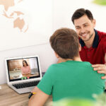 Father helping his teenager son with homework indoors