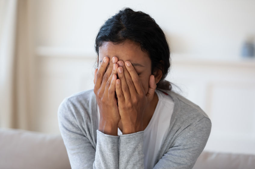 Sad and crying black woman cover face with hands