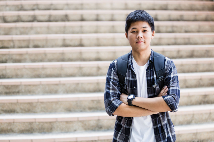 Unhappy teenage student sitting outside on stadium steps