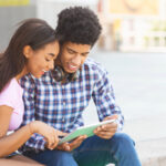 Cheerful african teenagers using digital tablet together
