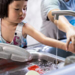 Girl and mom washing dishes, Positive Discipline for Peace at Home