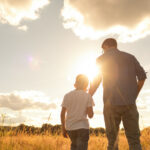 Father and son bonding and watching a beautiful sunset together - parenting benefits for employees - Peace at Home Parenting Solutions